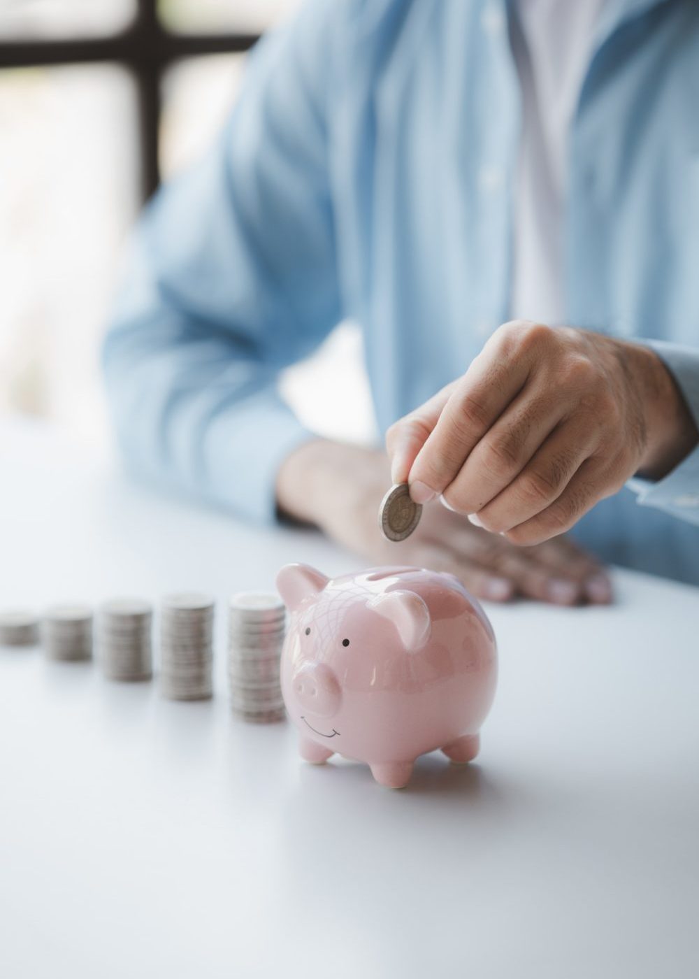 person-with-pile-of-coins-and-piggy-bank-money-saving-concept-for-future
